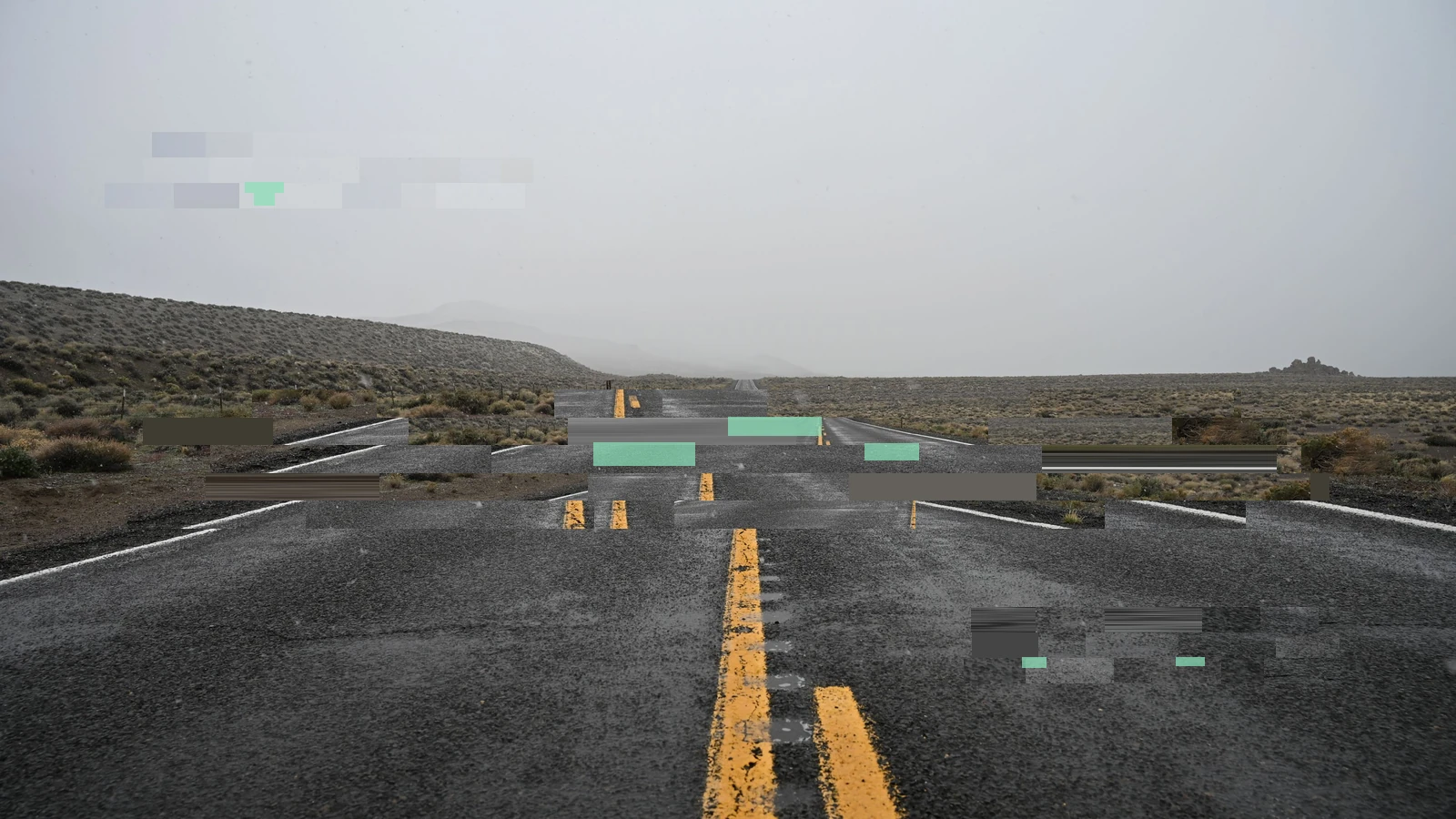 An empty road vanishing into a flat grey desert horizon, interrupted by broad digital fragments and small coloured blocks.